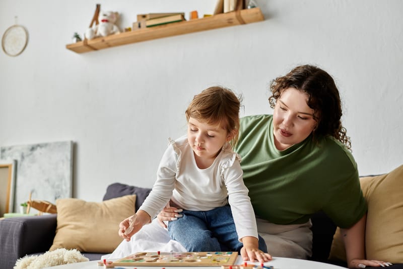 A loving plus size mother shares quality time with her daughter while playing a game indoors